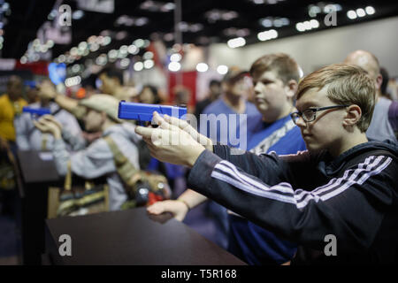 Indianapolis, Indiana, USA. 26 Apr, 2019. Ein junge Triebe Ziele mit einem Laser Gewehr auf die Laserlyte stand während der National Convention der National Rifle Association. Quelle: Jeremy Hogan/SOPA Images/ZUMA Draht/Alamy leben Nachrichten Stockfoto