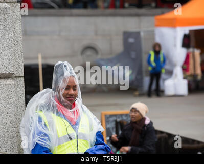 London, Großbritannien. 27 Apr, 2019. Ein Mitglied des Sicherheitspersonals trägt ein Poncho als Schutz vor dem Regen am Vaisakhi Festival, auf dem Trafalgar Square in London. Credit: Keith Larby/Alamy leben Nachrichten Stockfoto