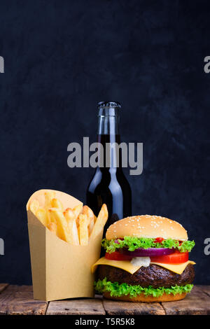 Burger mit Pommes Frites und Getränk auf hölzernen Tisch Stockfoto