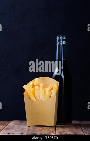 Pommes frites und einem Getränk auf hölzernen Tisch Stockfoto