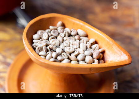 Nahaufnahme raw Green coffee bean in der Keramik Schale Stockfoto