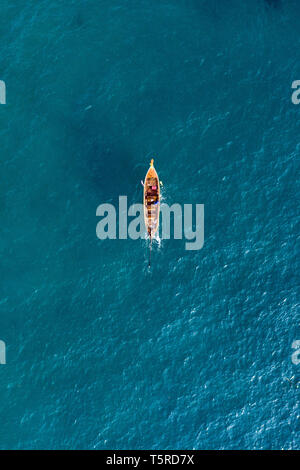 Ansicht von oben, aus der Vogelperspektive einen schönen long tail Boot segeln auf einem türkisfarbenen Meer. Phi Phi Islands, Maya Bay, Provinz Krabi, Thailand. Stockfoto