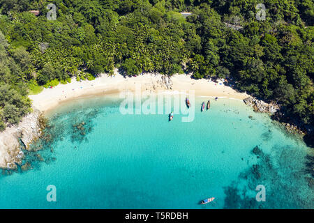 Ansicht von oben, aus der Vogelperspektive einen wunderschönen tropischen Strand mit weißem Sand und türkisfarbenem Wasser, long tail Boote und Menschen zu sonnen. Stockfoto