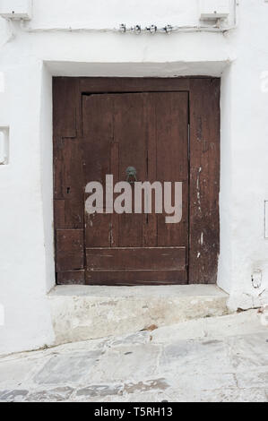 Alte groben braunen Holztür in weiß gestrichene Wand Stockfoto