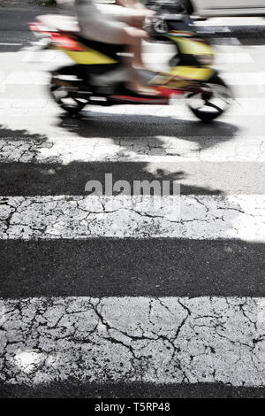 Schwarze und weiße Fußgängerüberweg mit einem Motorroller auf Hintergrund Stockfoto