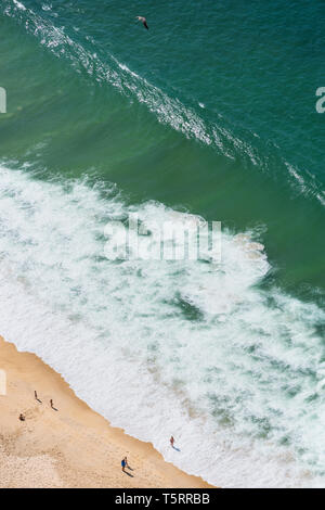 Luftaufnahme von Menschen beim Sonnenbaden auf dem Ocean Beach an heißen Sommertagen mit smaragdgrünen Meer Wellen Stockfoto