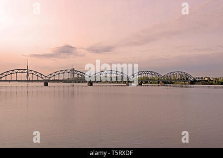 Eisenbahnbrücke über den Fluss Daugava und Fernsehturm in Riga, Lettland Stockfoto