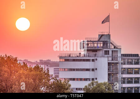 Rotterdam, Niederlande, 21. April 2019: Eine feurige Sonne über dem oberen Teil des monumentalen Van Nelle Fabrik einschließlich der iconing Teestube Stockfoto