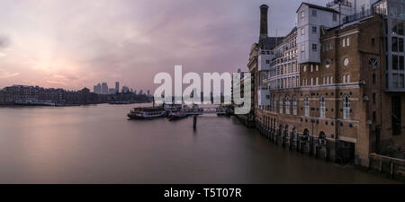 Früh Morgens den Sonnenaufgang in der Nähe der Tower Bridge in London mit Flussblick und Boote an der Themse. Stockfoto