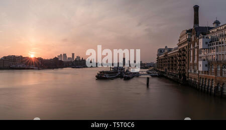 Früh Morgens den Sonnenaufgang in der Nähe der Tower Bridge in London mit Flussblick und Boote an der Themse. Stockfoto