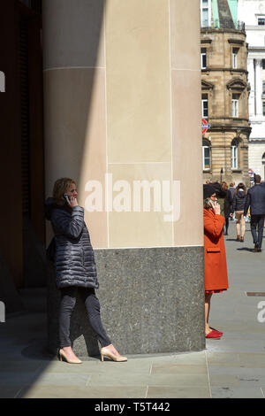 Zwei Frauen mit Handys in der Londoner City Stockfoto