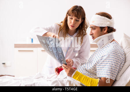 Junger Arzt untersuchen verletzte Patienten Stockfoto