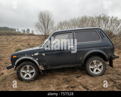 Moskau, Russland - Dezember 25, 2018: Schwarzer russischer Geländewagen Lada Niva 4x4 (VAZ 2121 / 21214) auf dem Feld geparkt. Stockfoto