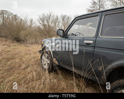 Moskau, Russland - Dezember 25, 2018: Schwarzer russischer Geländewagen Lada Niva 4x4 (VAZ 2121 / 21214) auf dem Feld geparkt. Stockfoto