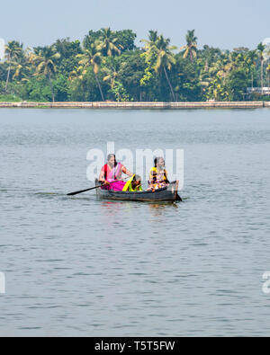 Vertikale Ansicht der Damen, die in einer Lagune paddeln in einem Kanu in Alleppy, Indien Stockfoto