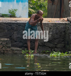 Platz Porträt eines Mannes mit einer Waschen am Ufer in Alleppy, Indien Stockfoto