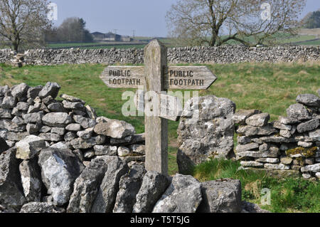 Wanderweg Wegweiser in den Peak District, Derbyshire, in der Nähe von Monyash mit lokalen Trockenmauern Stockfoto