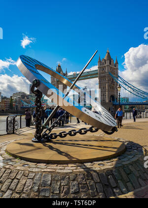 Blick auf die sonnenuhr an der St. Katharine Docks und die Tower Bridge über die Themse in London an einem sonnigen Tag. Stockfoto