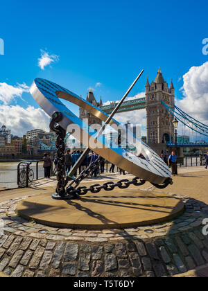 Blick auf die sonnenuhr an der St. Katharine Docks und die Tower Bridge über die Themse in London an einem sonnigen Tag. Stockfoto