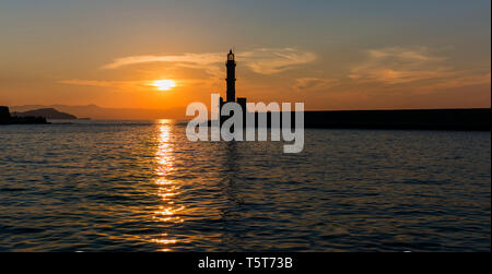 Die silhoutte der Leuchtturm im Hafen von Chania, eine Stadt auf der Insel Kreta, Griechenland während des Sonnenuntergangs. Stockfoto