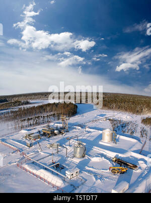 Öl- und Gasindustrie. Die Arbeit der Ölpumpe Buchse auf einem Ölfeld.. Baustelle in wild Winter Forest. Bau von petrochemischen Anlagen Stockfoto