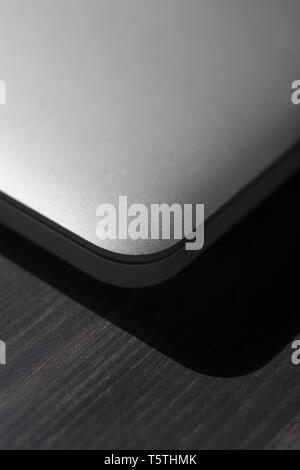 Geschlossener Laptop auf einer Holzoberfläche Stockfoto