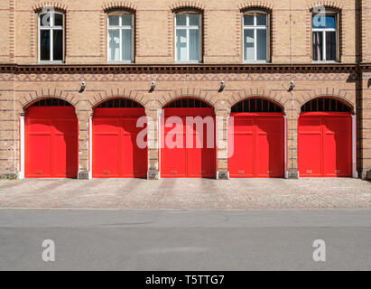 Feuerwehr Gebäudes Fassade mit roten Türen und leere Straße Stockfoto