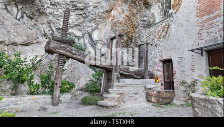 Alte landwirtschaftliche Geräte. Alte hölzerne Weinpresse von 1759 in der Einsiedelei Santa Caterina del Sasso am Lago Maggiore, Italien Stockfoto