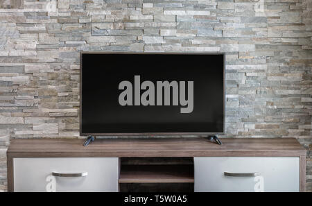 Wohnzimmer innen Hintergrund Wand weiß wild Stein und ein Plasma TV Panel auf eine lange Möbel Nachttisch Stockfoto