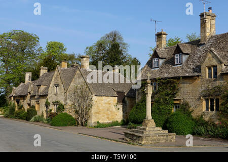 Reihe von Steinhäusern und Kriegerdenkmal in den Cotswolds England Stockfoto