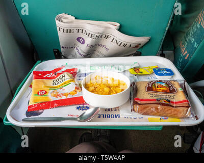 First Class Sitz auf indische Eisenbahn Express Zug mit einer Kopie des Indischen Zeiten und kostenloses Frühstück mit verpackten Toast und Corn Flakes Stockfoto