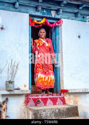 Frau auf dem eingerichtet und garlanded Schwelle von ihrem Haus in dem abgelegenen Dorf Satri im binsar Region Uttarakhand Himalaya