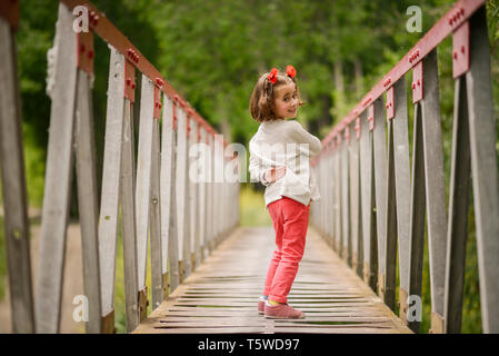 Süße kleine Mädchen Spaß in einer ländlichen Brücke Stockfoto