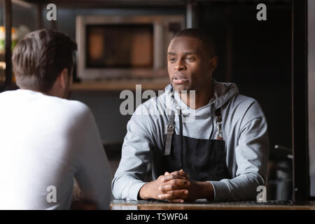 Afrikanische Koch im Gespräch mit kaukasischen männliche Vakanz Kandidat im Restaurant Stockfoto