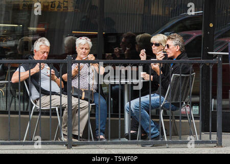 Vier Männer im mittleren Alter und Frauen am Tisch essen Eis gemeinsam eine Landschaft in der Innenstadt von Seattle, USA. Stockfoto