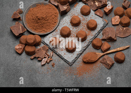 Classic Schokolade Trüffel und Stücke Schokolade auf dunklen konkreten Hintergrund Stockfoto