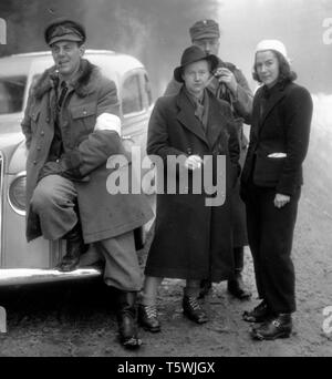 Der Winterkrieg. Ein militärischer Konflikt zwischen der Sowjetunion und Finnland. Sie begann mit einer sowjetischen Invasion im november 1939, als die sowjetische Infanterie die Grenze zum Karelischen Isthmus überquerte. Etwa 9500 schwedische Freiwillige nahmen am Krieg Teil. In der Mitte des legendären schwedischen Journalisten Barbro Alving. Bereits ein erfahrener Kriegsberichterstatter, der vom spanischen Bürgerkrieg berichtete. Hier der Karelische Isthmus Finnland im Dezember 1939 mit finnischen Soldaten, die sie begleiten sollten. Er verließ Erik Wästberg, schwedischer Journalist der Tageszeitung. Foto Kristoffersson Ref. 100-4 das Auto ist ein Volvo PV Stockfoto