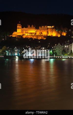 Heidelbergs beleuchtete Schloss von der Altstadt Brücke aufgenommen mit der Lichtreflexe auf dem Wasser des Flusses Neckar Stockfoto