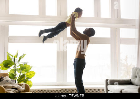 Happy afrikanischen Vater hob in der kleinen Sohn Stockfoto