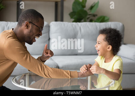 Schwarzen Vaters Lachen das Spiel mit dem kleinen Kind zu Hause Stockfoto