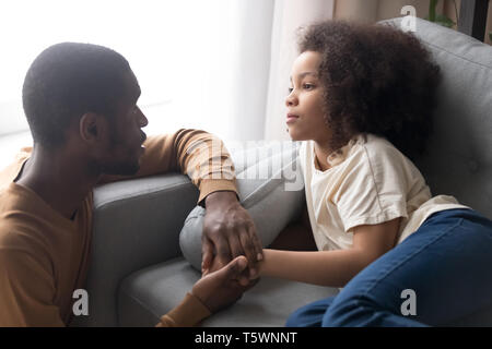 Vater halten Hand kleine Tochter liegend auf dem Sofa unwohl fühlt Stockfoto