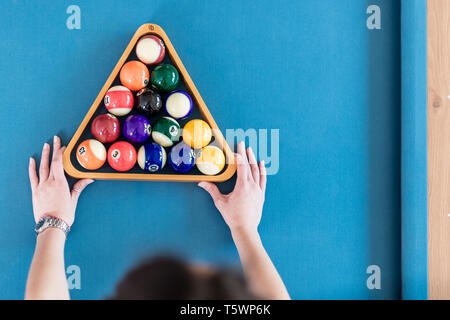 Hohe Betrachtungswinkel der weiblichen Holding Dreieck Holz- Rack mit pool Kugeln auf den Billardtisch. Platz für Kopieren. Stockfoto