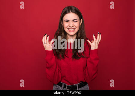 Close up isolierte Porträt der jungen genervt wütende Frau Hände halten in Furiosen Geste auf roten Hintergrund. Stockfoto