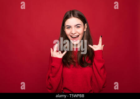 Portrait von lauten Ton Musikliebhaber brünette Haar Dame sie auf rot leuchtenden Hintergrund mit Kopie Platz für Text zeigen Ihr Rock'n'Roll punk sign wkn isoliert Stockfoto