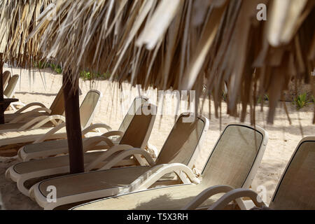 Liegen im Schatten der Sonnenschirme aus Palmblättern Stockfoto