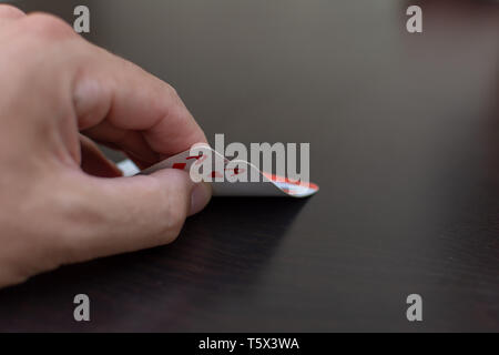 RAK, RAK/VAE - 4/20/2019: 'Pocket (Paar) Asse in einem Pokerspiel mit einer Hand und Schwarzen Tisch macht wahrscheinlich die Wette eine Hand in diesem Spiel zu gewinnen." Stockfoto