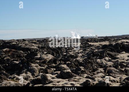 Blaue Lagune Grindavik (Bláa Lónið) - Blick über Lavafeld auf entfernten dampfende Pools, Island Stockfoto