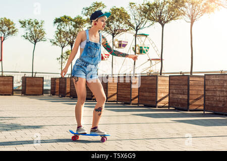 Junge alternative Mädchen skater tragen Kappe auf der Straße reiten penny Vorstand freuen uns motiviert Stockfoto