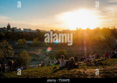 Berlin, Deutschland - April 2019: Personen, die Aussicht auf den Sonnenuntergang Himmel über Skyline von öffentlichen Park (Mauerpark) auf Summer Day in Berlin Stockfoto