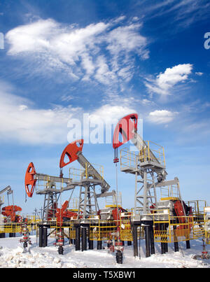 Öl- und Gasindustrie. Die Arbeit der Ölpumpe Buchse auf einem Ölfeld. Weiße  Wolken und blauer Himmel über Ölfeld Stockfotografie - Alamy